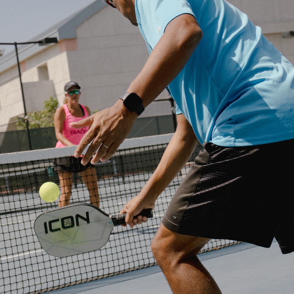 Individuals actively engaging in a community Pickleball match